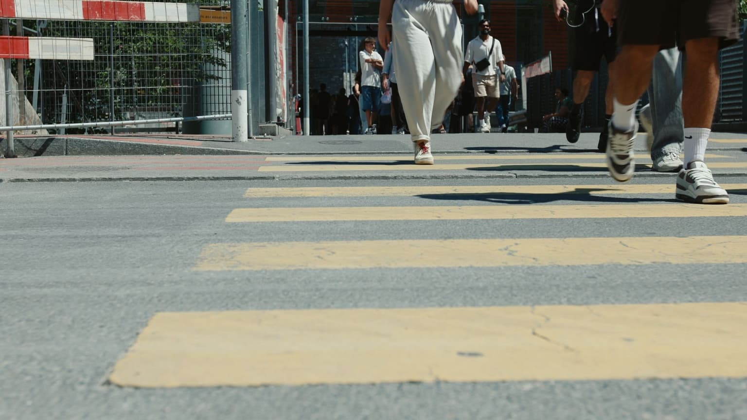 Official Stupid Shoes promotional still showing people walking across a street
